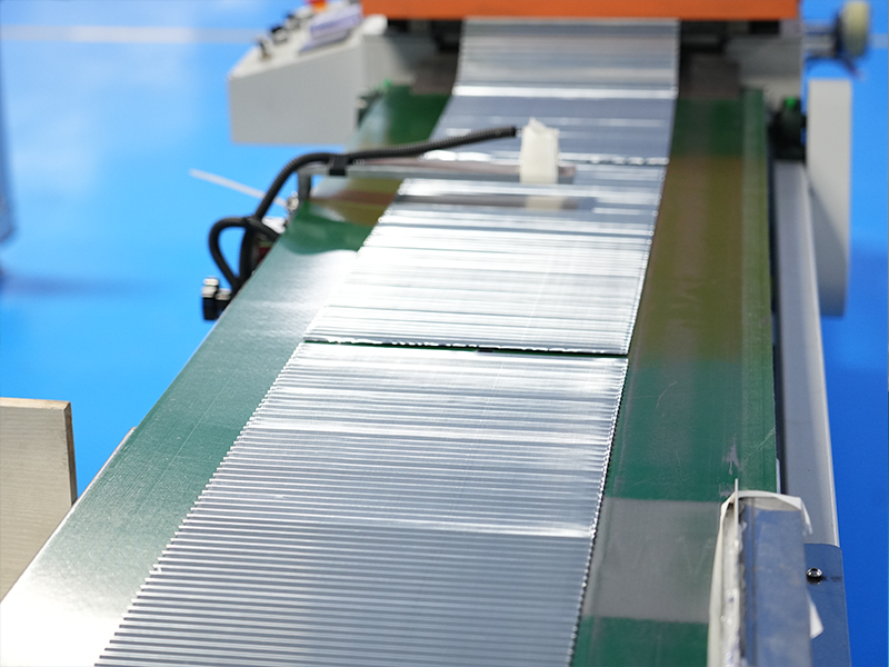 Close-up of pleated metal strip production for air filter structural components